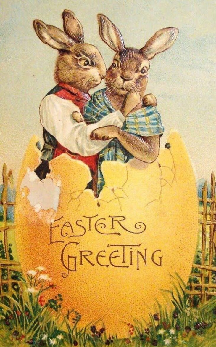 Два зайца в пасхальных нарядах с поздравительной открыткой Easter Greeting.