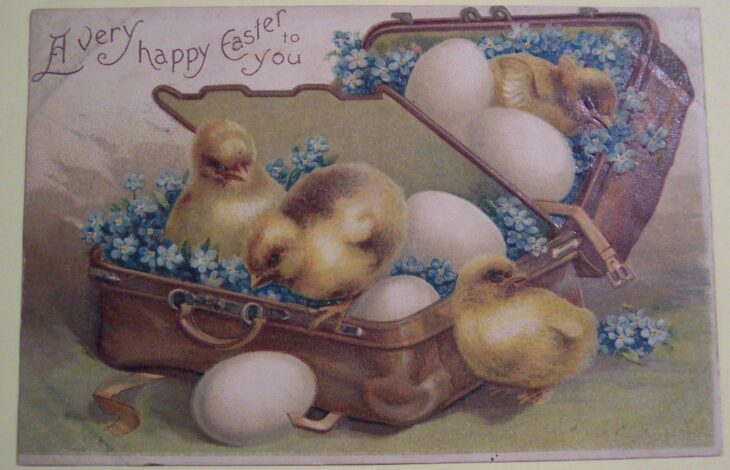 пасхальное поздравительное изображение с цыплятами и яйцами в чемодане окруженные голубыми цветами